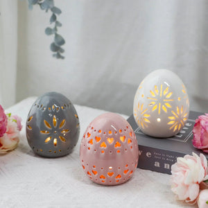 Set of 3 ceramic egg lamps, 4 in high, battery-powered, pastel gray pink ivory with carved cutouts.