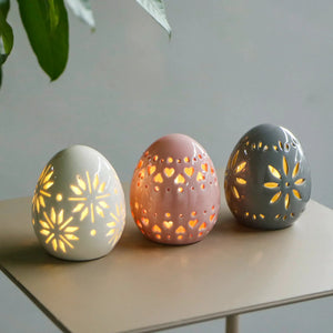 Set of 3 ceramic decorative lamp eggs, 4 inches tall, battery-operated; white, pink and gray with carved cutouts.