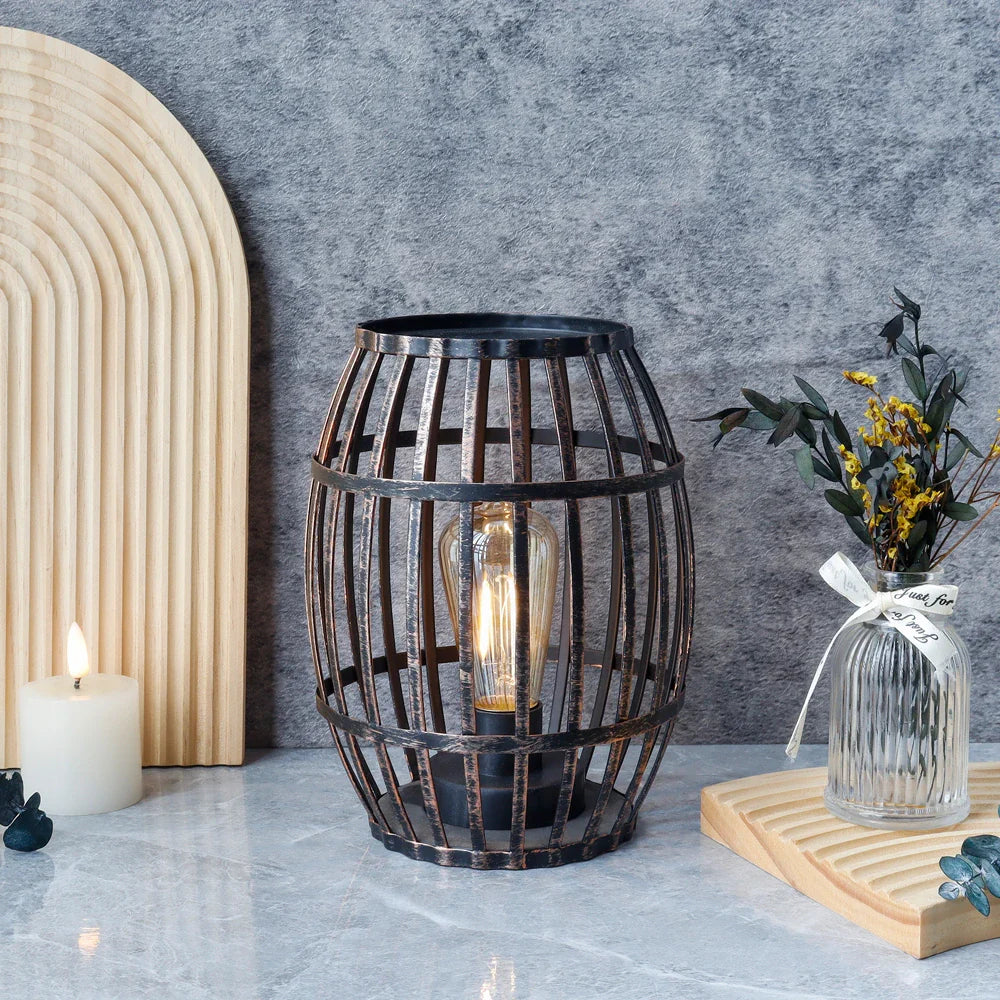 Cordless battery-operated metal wine barrel lamp with black brushed-gold finish and visible Edison-style bulb.