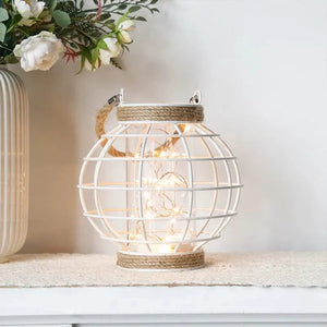 7.3in H white metal cage LED lantern, battery-powered with warm white string lights