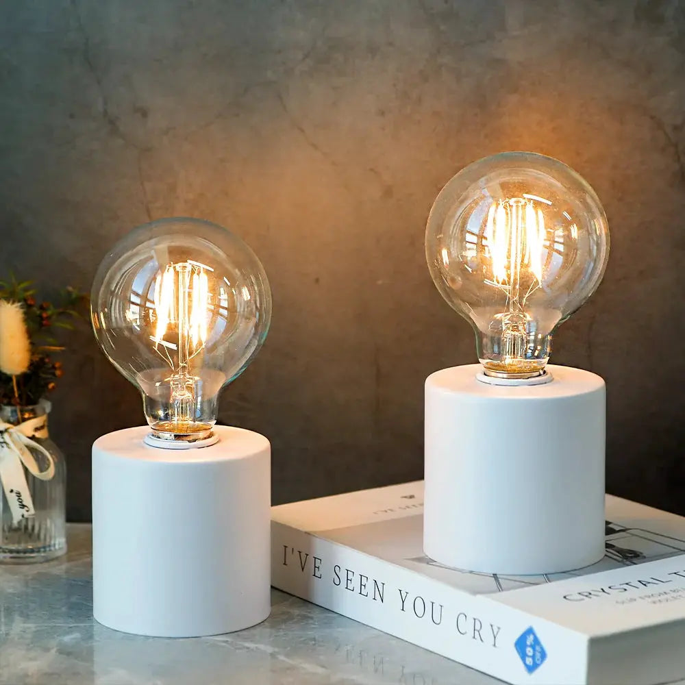 Set of 2 white battery-powered table lamps with cylindrical bases and clear bulbs