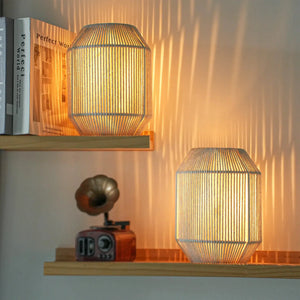 Set of 2 woven shade table lamps with beige tones and warm glow on shelf