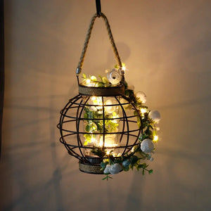JHY DESIGN 7.3-inch battery-powered table lamp with hemp rope cage, hanging lantern wrapped in greenery and warm fairy lights.