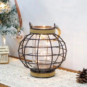 Battery-powered lamp featuring a spherical black metal wire cage wrapped in hemp rope, glass jar with warm fairy lights by JHY DESIGN