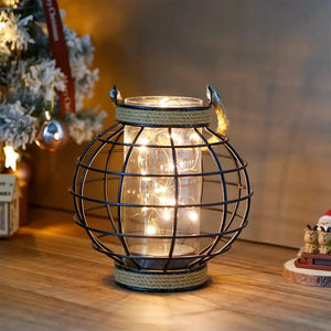 7.3-inch tall battery-powered table lamp with a black wire globe cage, glass jar core, and hemp rope trim with warm fairy lights.