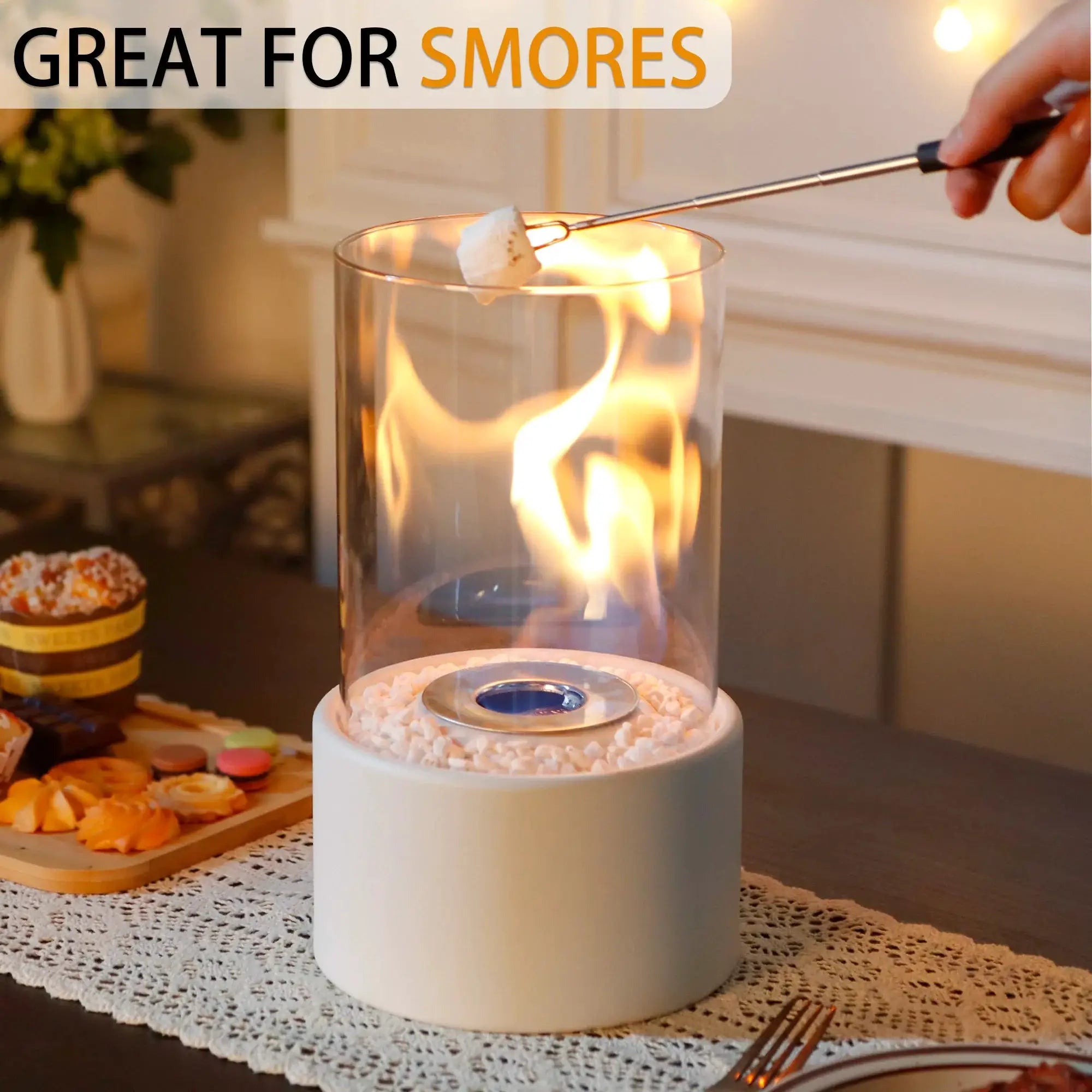 Tabletop fire bowl, 10.5 in tall, with a clear glass cylinder, white base, and white decorative pebbles around the burner.