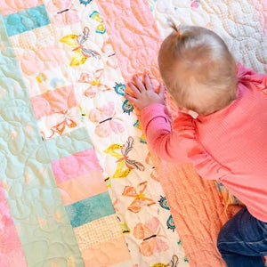 Quilt kit Bricks and Beams Butterflies by Block Party Quilt Co; pastel butterfly fabric quilt laid out.