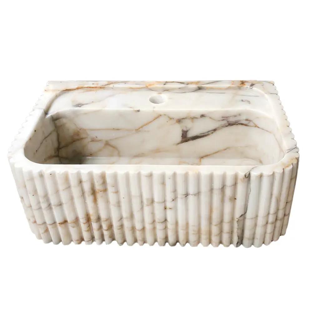 Calacatta Gold marble wall-mount bathroom vanity sink, fluted exterior, white with gold veining.