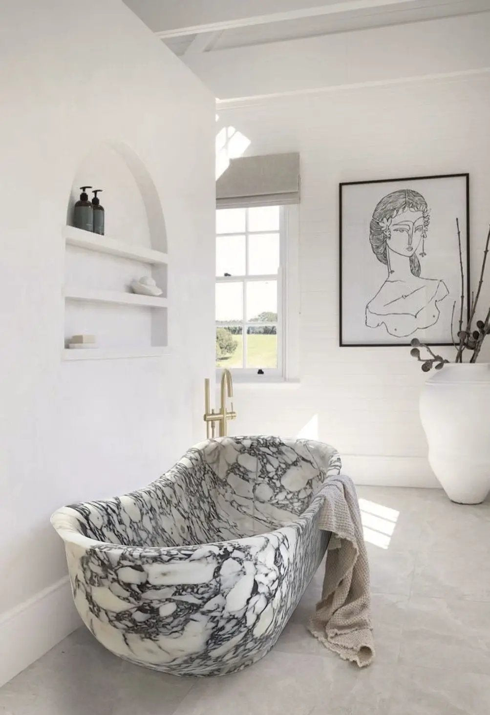 Calacatta Viola freestanding bathtub hand-carved from solid white marble with bold veining.