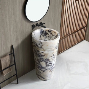 Calacatta Viola marble pedestal sink by Villohome; white marble with gray veining and a black faucet.