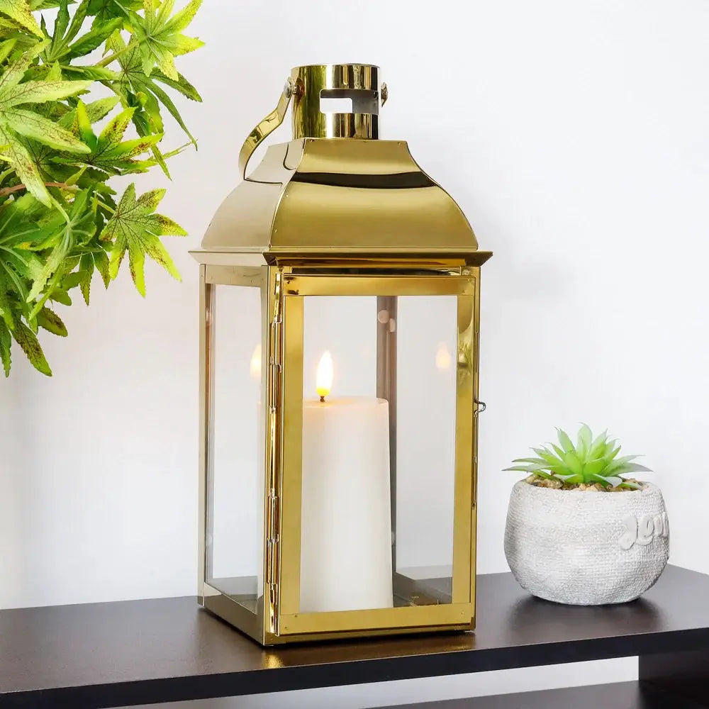 12.5" High decorative lantern by JHY DESIGN in gold metal with glass panels and a candle inside
