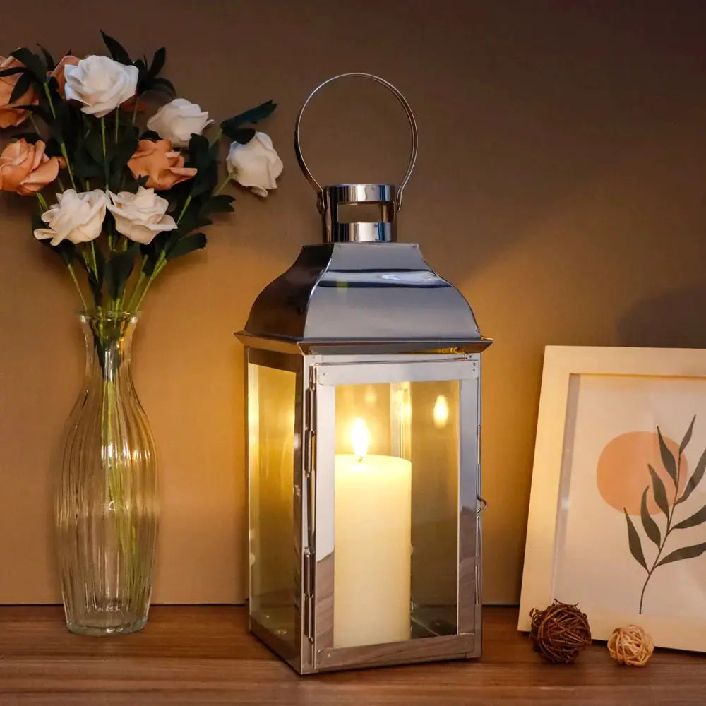 12.5” High decorative candle lantern by JHY DESIGN with metal frame and glass panels, lit candle inside.