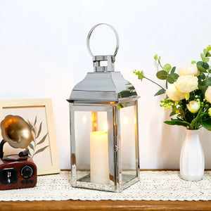 Decorative candle lantern by JHY DESIGN, 12.5 inches tall with chrome finish and a lit pillar candle.