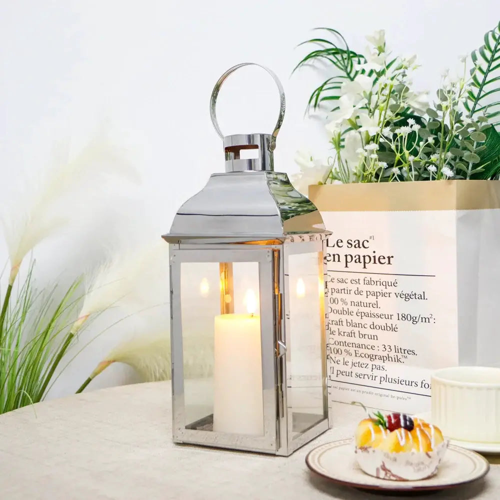 12.5-inch high decorative candle lanterns by JHY DESIGN, silver metal frame with glass panels and a lit candle.
