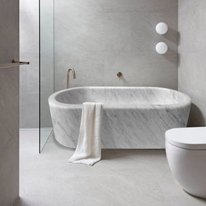Imperial White Marble Bathtub, hand-carved freestanding tub with copper fixtures in a gray-veined marble bathroom