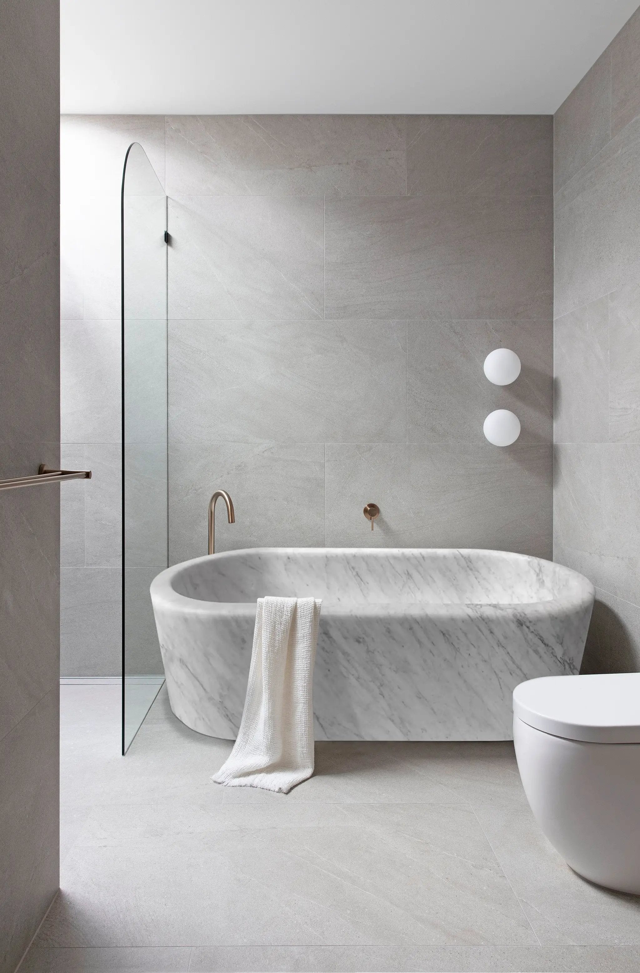 Villohome imperial white marble freestanding bathtub with veining and a towel draped over edge
