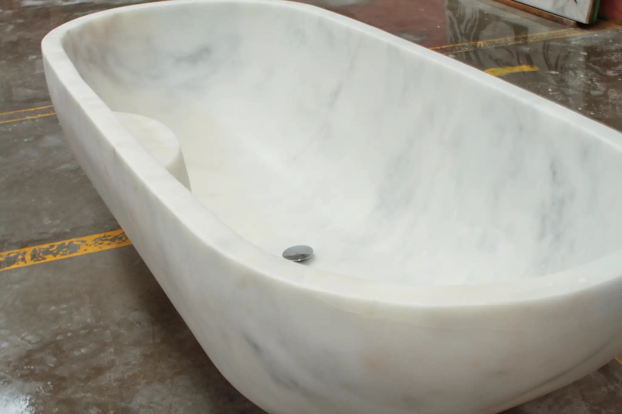 Bianco Carrara white marble bathtub, hand-carved from solid marble block, white with subtle gray veining.