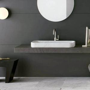 Carrara white marble rectangular above-vanity bathroom sink by Villohome on a dark gray countertop.