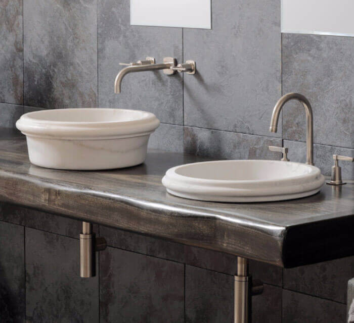 Carrara White Marble vanity sinks, 2 vessel basins on dark stone countertop with wall-mounted faucets