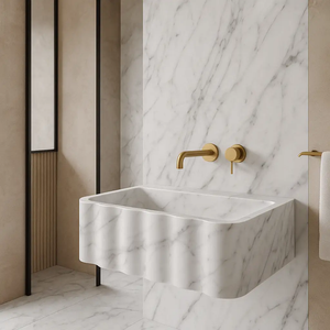 Carrara white marble wall-mount sink with fluted front and gold faucet fixtures, 28in long.