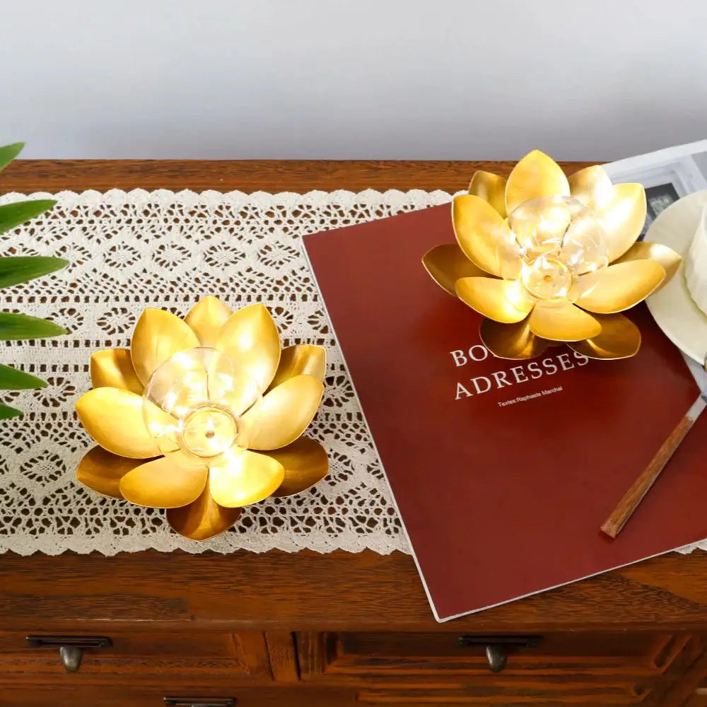 Gold-tone lotus table lamps, set of 2, battery-operated, on a wooden desk with a lace runner.