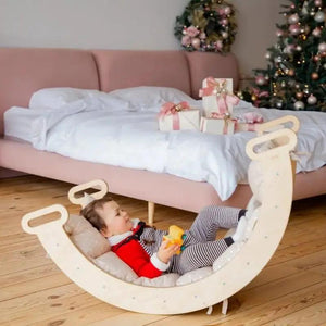 Goodevas balance cushion for climbing arch and rocker; soft beige crescent cushion with wooden handles.