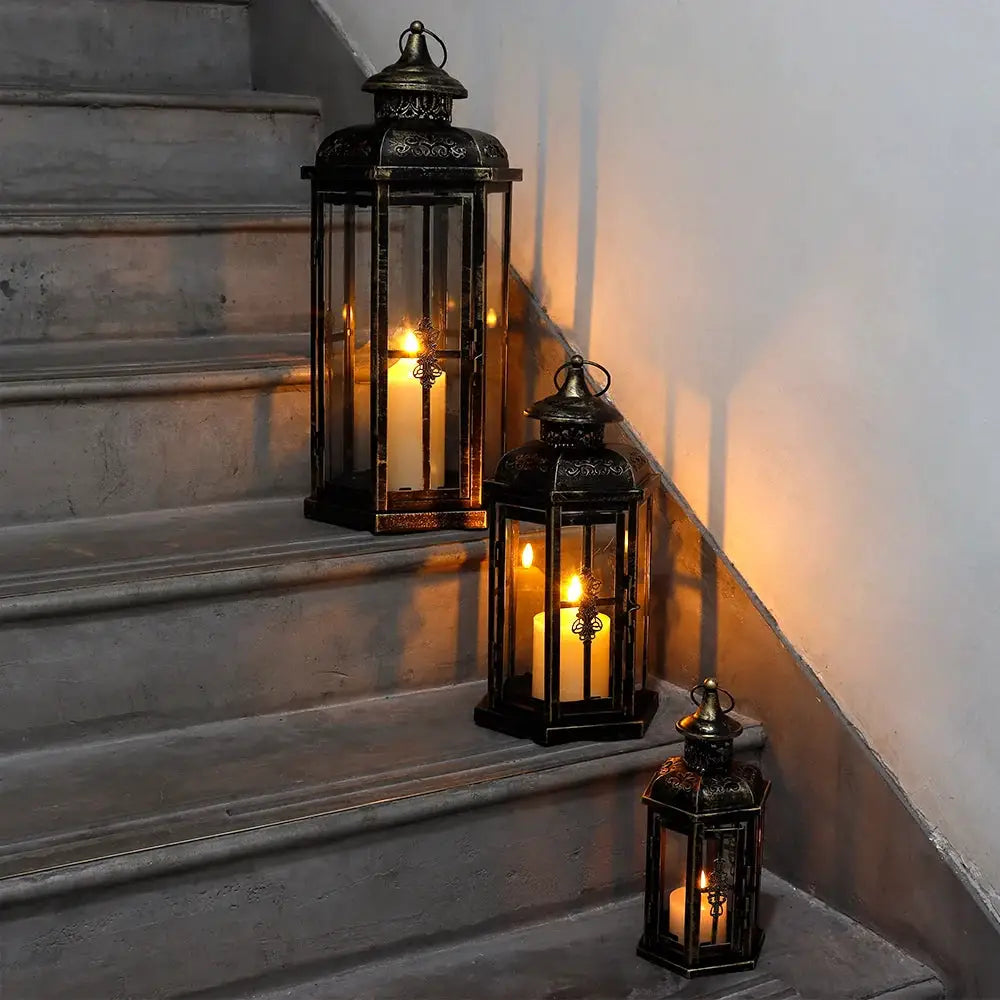 Set of 3 decorative candle lanterns, black with gold brush, vintage metal; heights 20.5 in, 14 in, and 10 in.