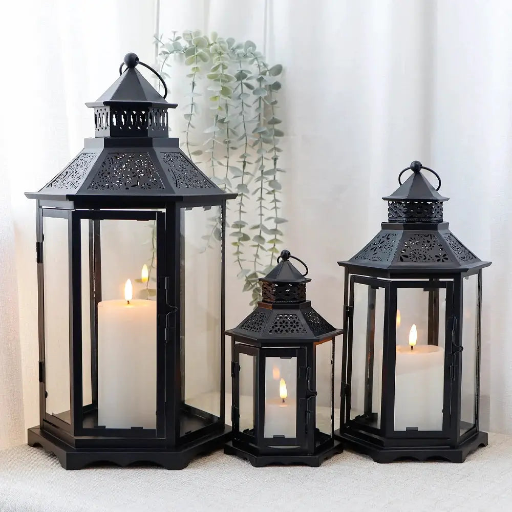 Decorative candle lanterns: set of 3 black hexagonal lanterns with glass panes and metal frames, heights 18in, 13in and 10in.