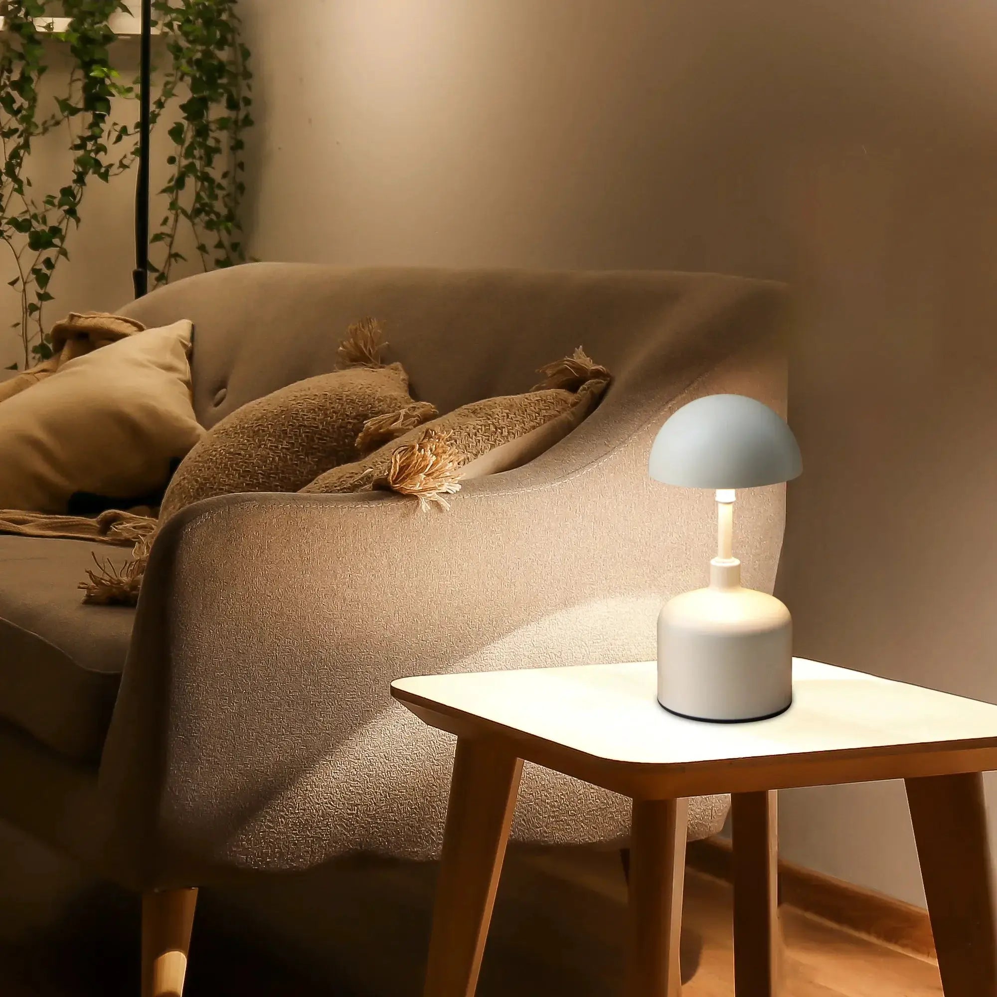 Set of 2 rechargeable mushroom lamps, white cordless lamps on a round white table beside a sofa.
