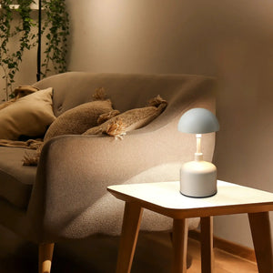 Set of 2 rechargeable mushroom lamps, white cordless lamps on a round white table beside a sofa.