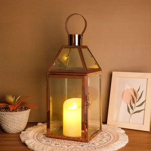 16-inch high decorative lantern, rose-gold metal with glass panels and candle inside