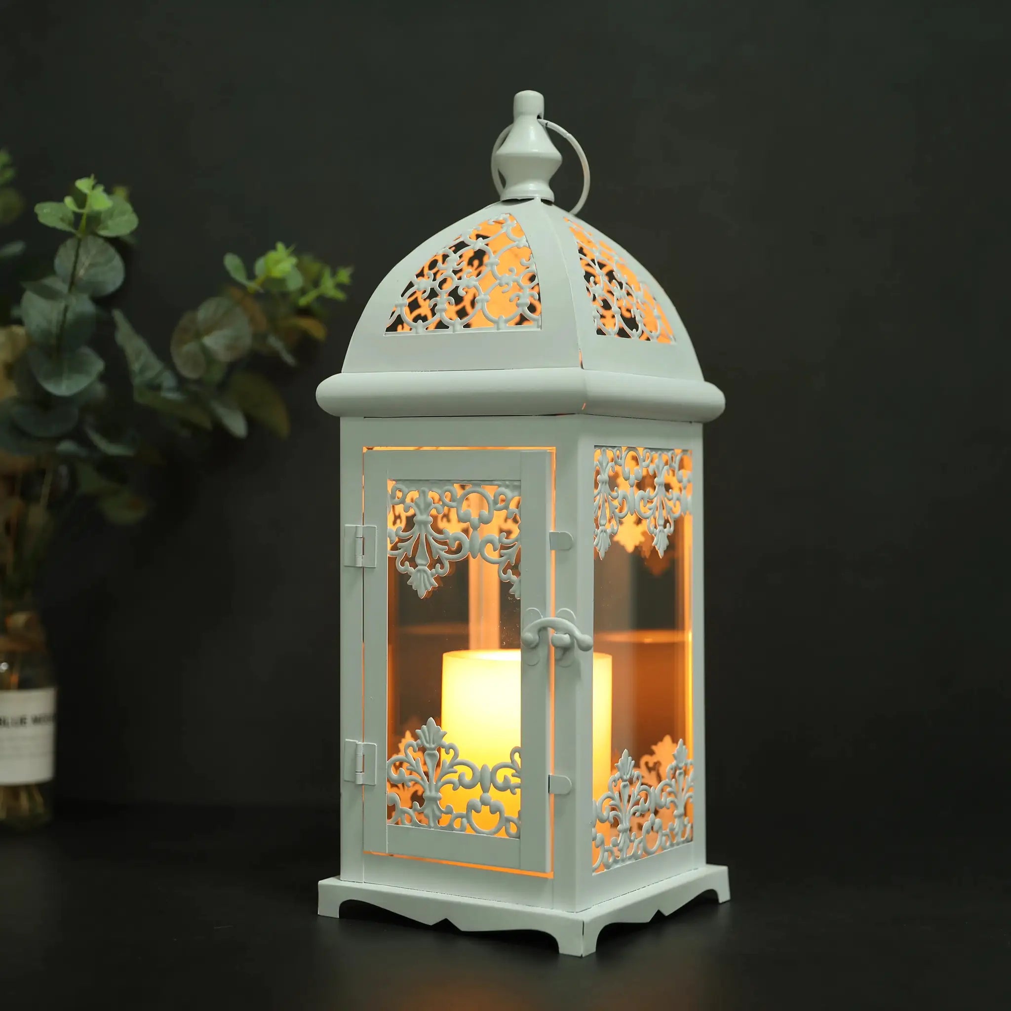 15-inch decorative candle lantern with pale blue metal frame and ornate cutout panels, warm glow.