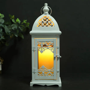 15-inch high decorative candle lantern, pale blue metal with ornate cutout lattice panels and a warm interior glow