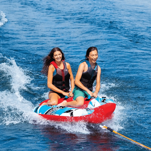 WOW Watersports Sub-Zilla 2-Person Towable; red and blue inflatable raft with two riders wearing life jackets.