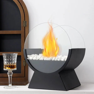 JHY DESIGN 13.5-in tall portable tabletop fireplace with black base, round glass guard and white stones.