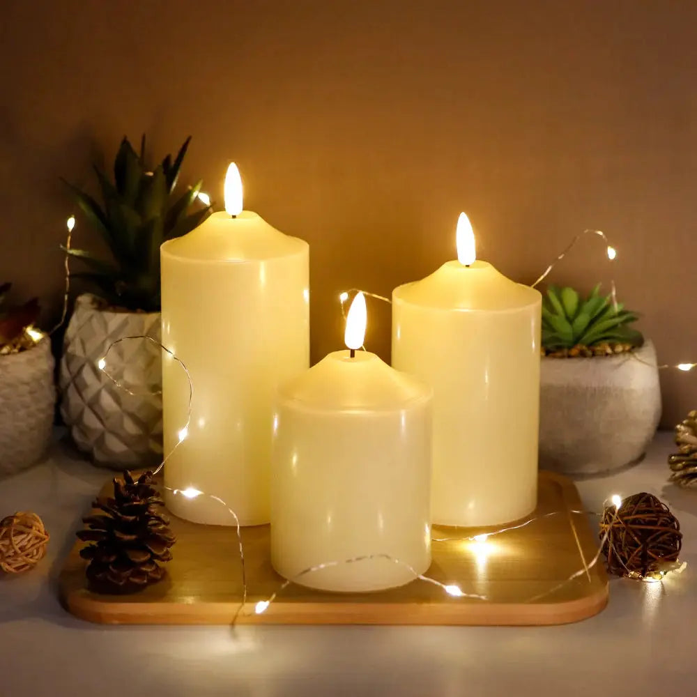 3D flameless candle set of 3 (4/5/6in), cream pillars on a wooden tray with string lights