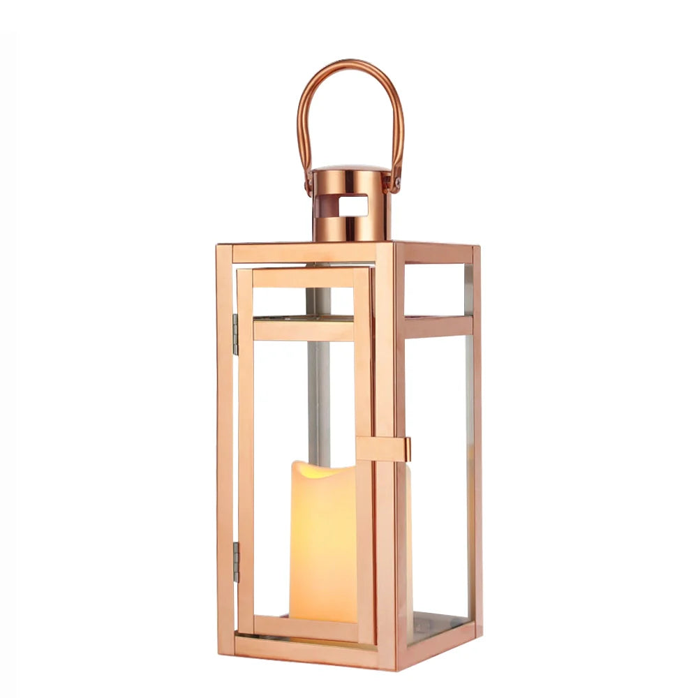 12'' high rose gold metal decorative candle lantern with glass sides; hangs or sits for display, candle glow inside.