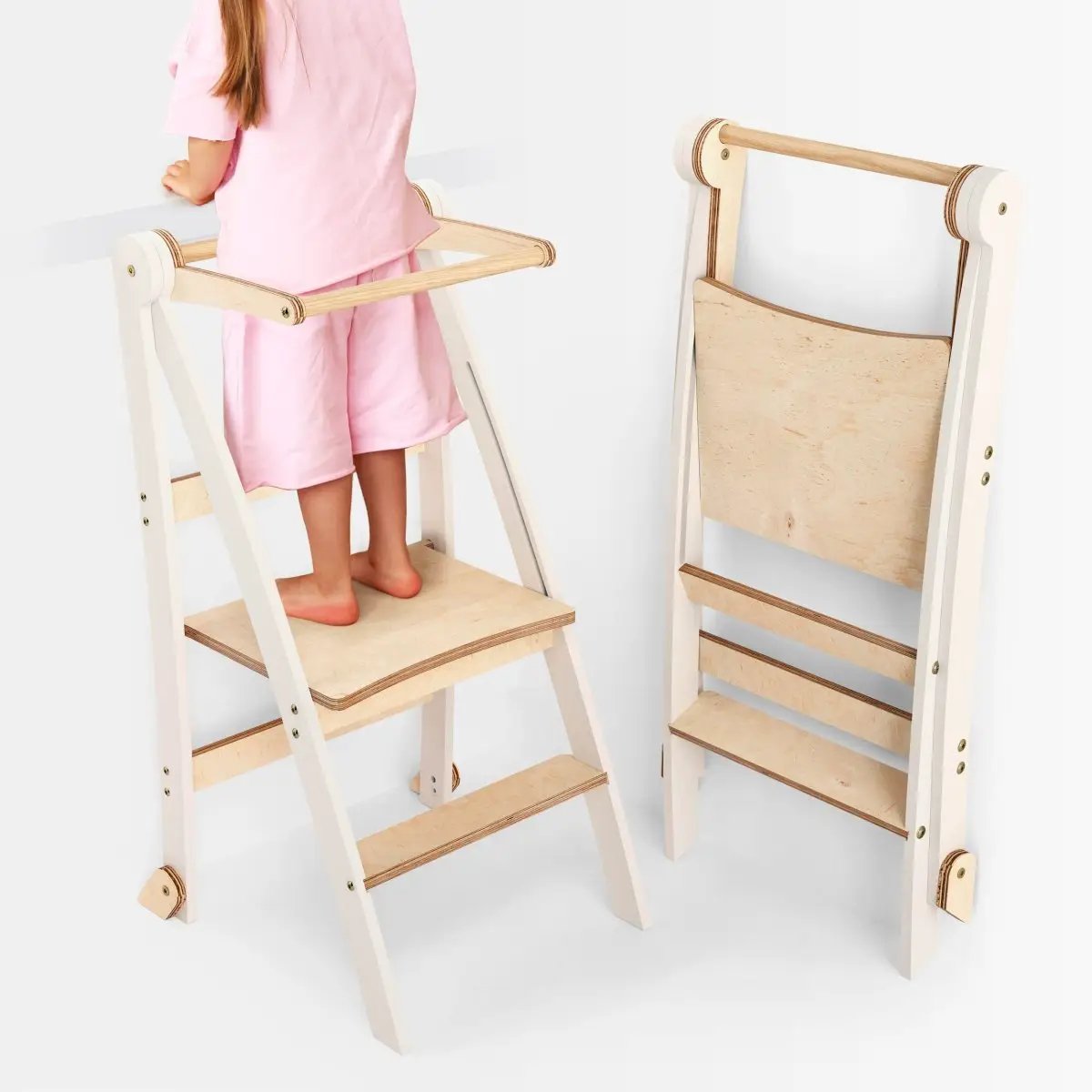 Helper Tower toddler step stool in white frame with natural wood steps; foldable, two towers shown
