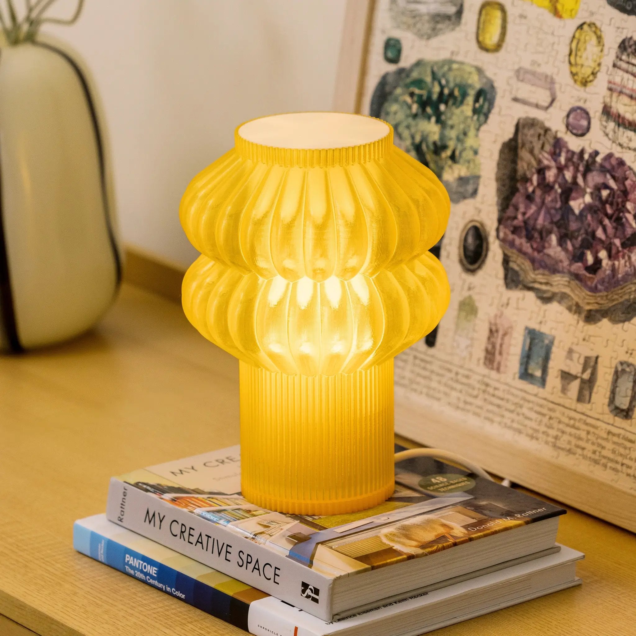 Oppi Table Lamp, yellow ribbed lamp, on a stack of three design books