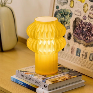 Oppi Table Lamp, yellow ribbed lamp, on a stack of three design books