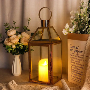Gold 16in stainless steel decorative candle lantern with glass panels and a lit candle inside