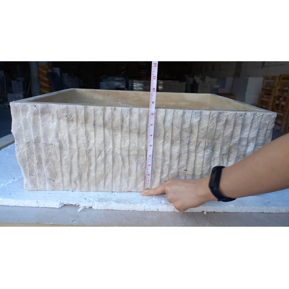 Travertine rectangular bathroom sink; natural stone with vertical ribbed exterior.