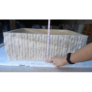 Travertine rectangular bathroom sink; natural stone with vertical ribbed exterior.