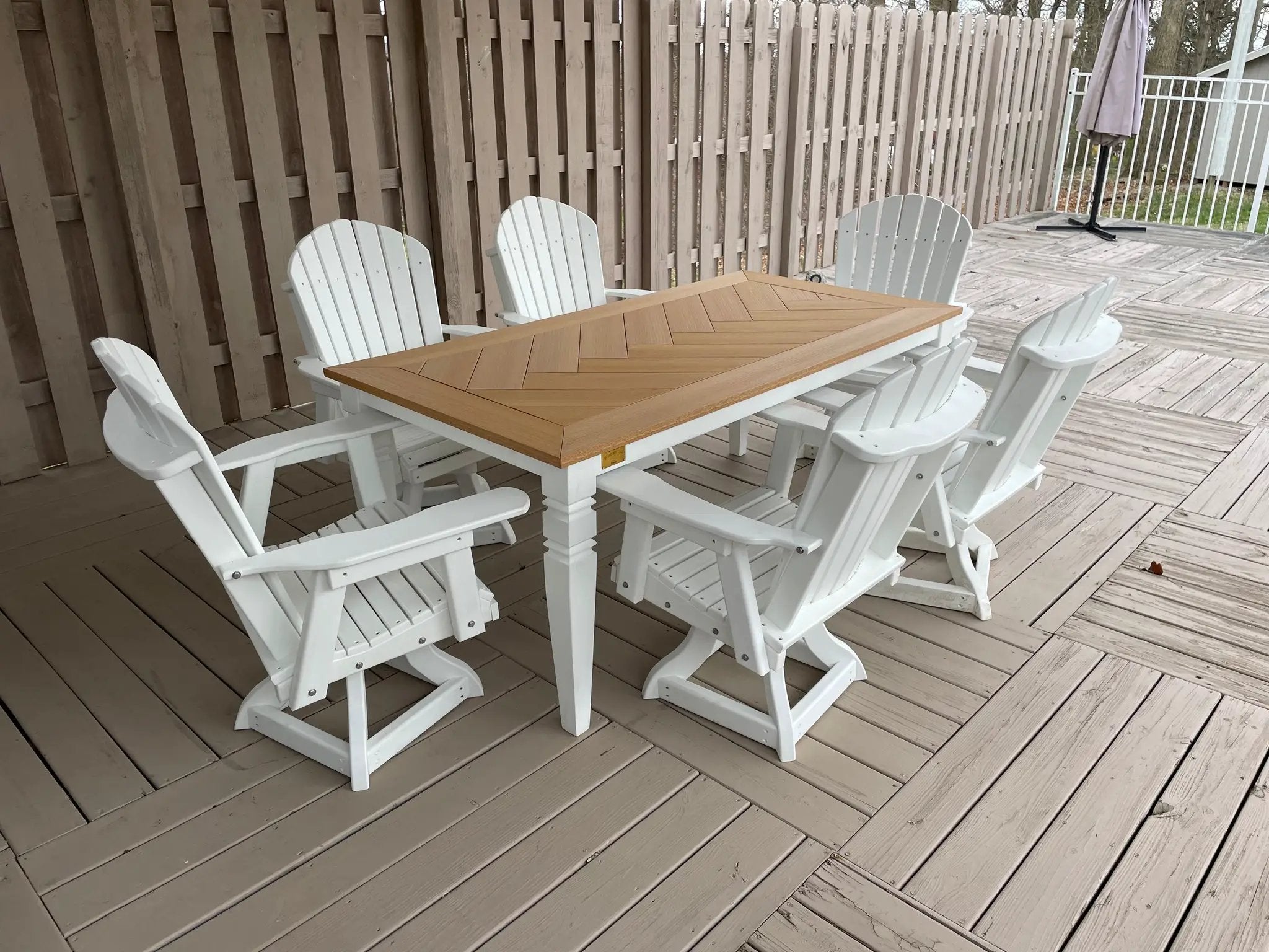 Java Leg Outdoor Dining Table with natural wood chevron top and white base on a wooden deck