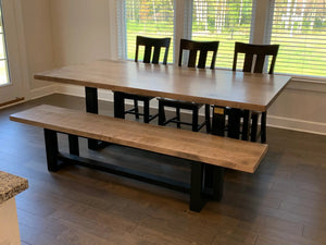 Heston dining table by Wooden Whale Workshop, light wood top with black legs, shown with benches and chairs.