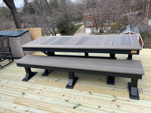 Trestle X Outdoor Bench by Wooden Whale Workshop; gray-stained slatted wood with black trestle legs on a deck.