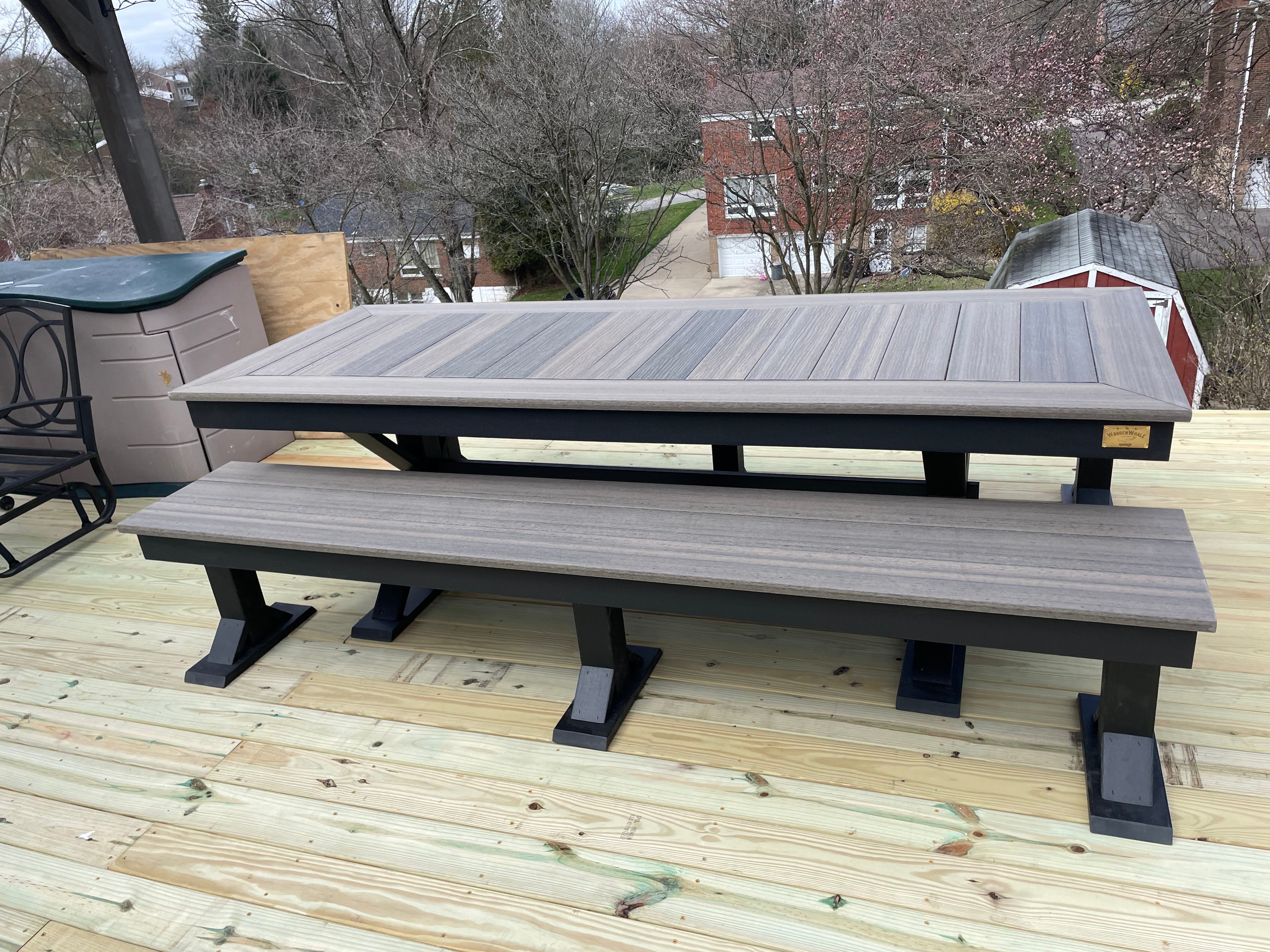 Trestle X Outdoor Bench by Wooden Whale Workshop; gray-stained slatted wood with black trestle legs on a deck.