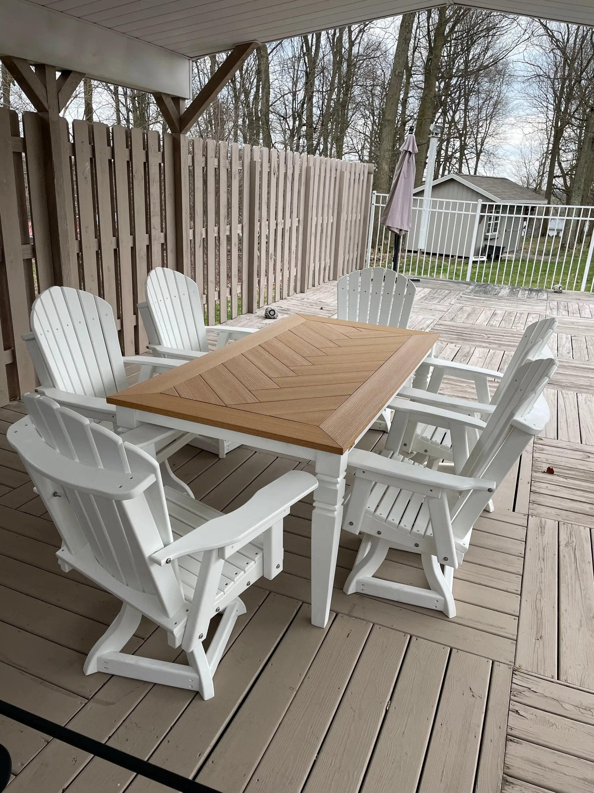 Java Leg Outdoor Dining Table - handcrafted wood top with brown finish and white legs, set on a deck with white chairs.