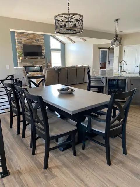 Vineyard Arm Chairs by Wooden Whale Workshop; six dark chairs around a light dining table in an open kitchen.
