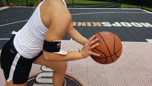 Bulls Eye Basketball Shooting Aid by HoopsKing worn on the forearm during outdoor shooting practice.